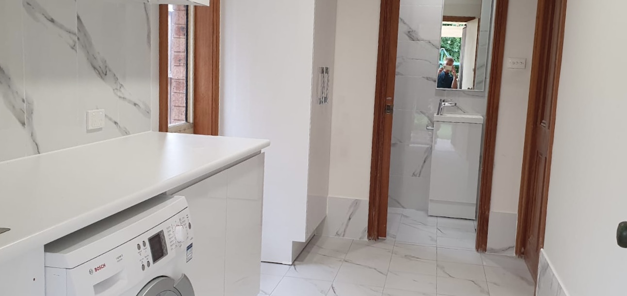 Laundry room with connecting bathroom