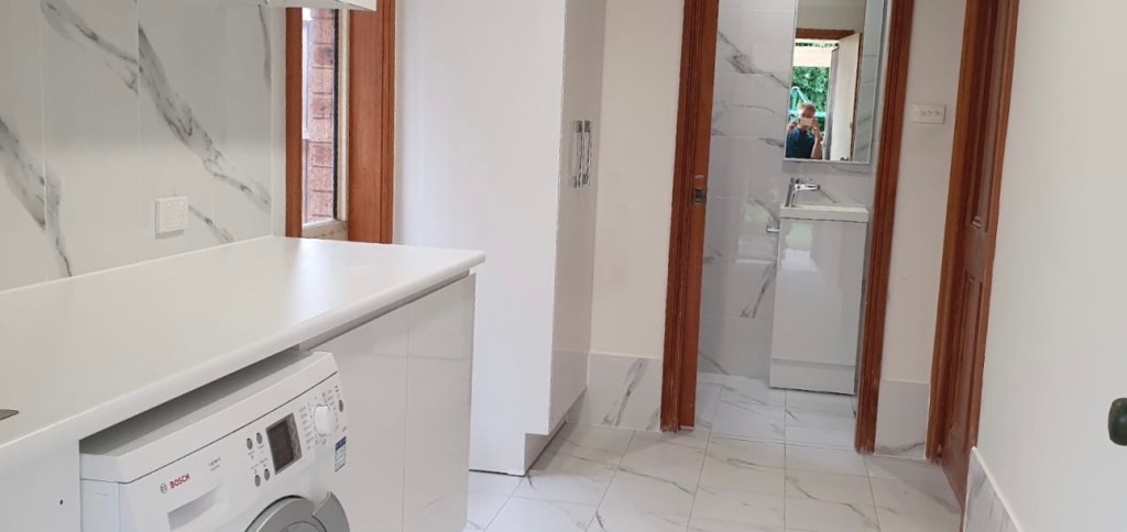 Laundry room with connecting bathroom